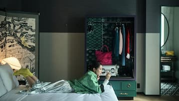 Una habitación de hotel con cama, armario y espejo.