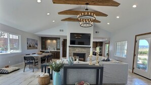 A spacious living area with a fireplace, a dining area, and a kitchen.