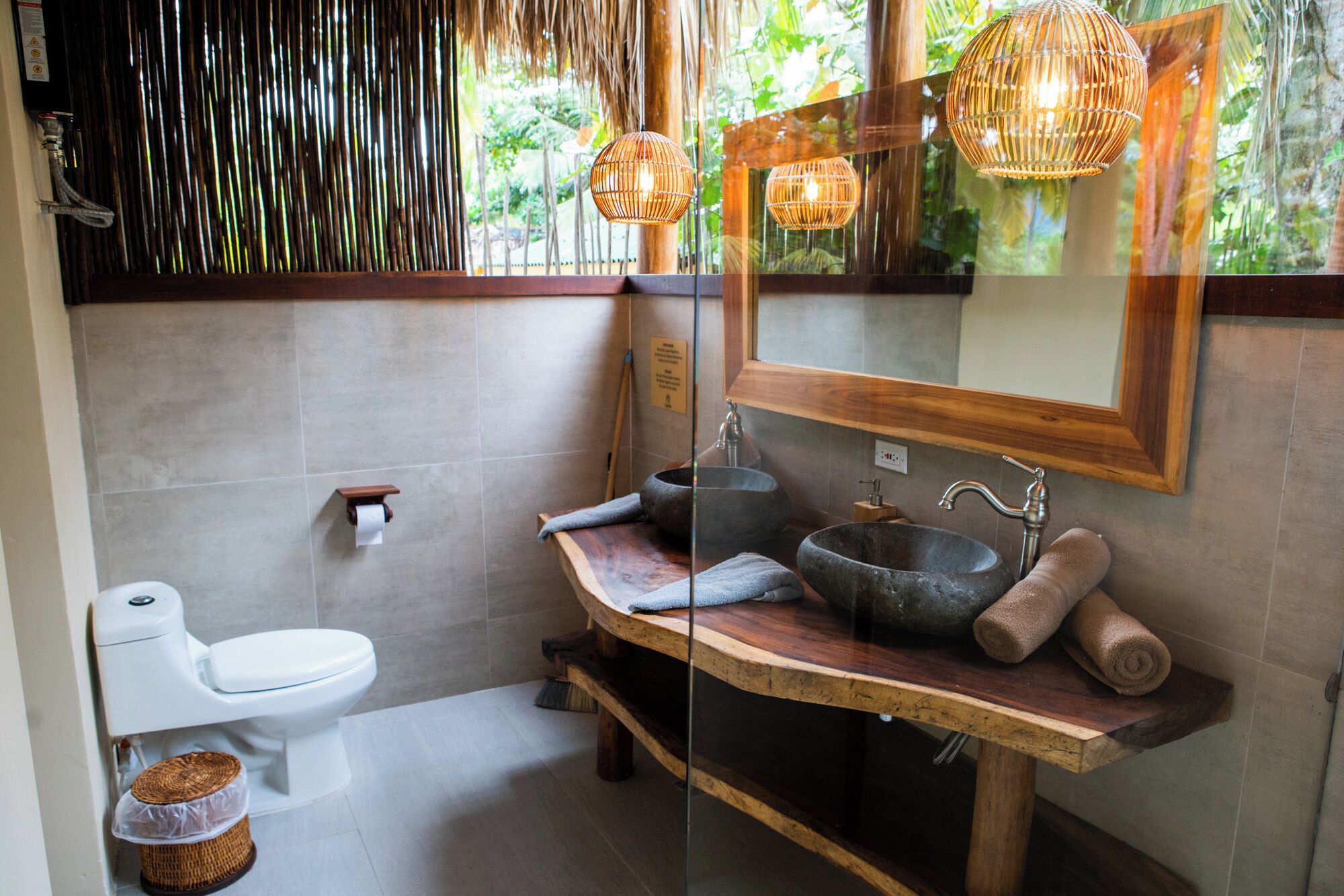 Une salle de bain avec un lavabo en pierre, un meuble-lavabo en bois et des toilettes.