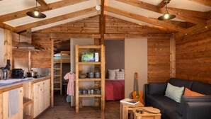 A cozy cabin interior with a kitchen, dining area, and a living room.