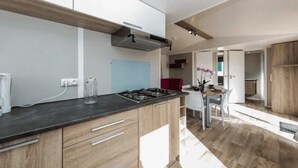 Una cocina moderna con armarios de madera, una estufa a gas y una pared azul.