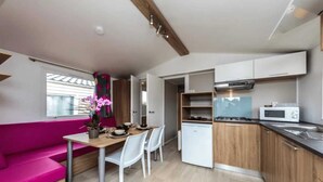 A compact kitchen with a dining area, a microwave, and a small refrigerator.