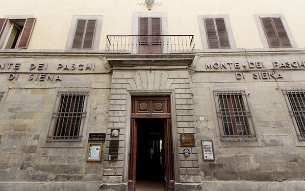 A building facade with the inscription "Monte dei Paschi di Siena" and a door entrance.