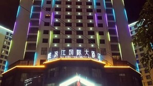 A multi-story building with illuminated signage and windows. - Weiyuan River International Hotel (Jinggu)