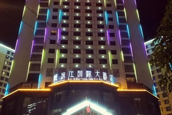 A multi-story building with illuminated signage and windows. - Weiyuan River International Hotel (Jinggu)