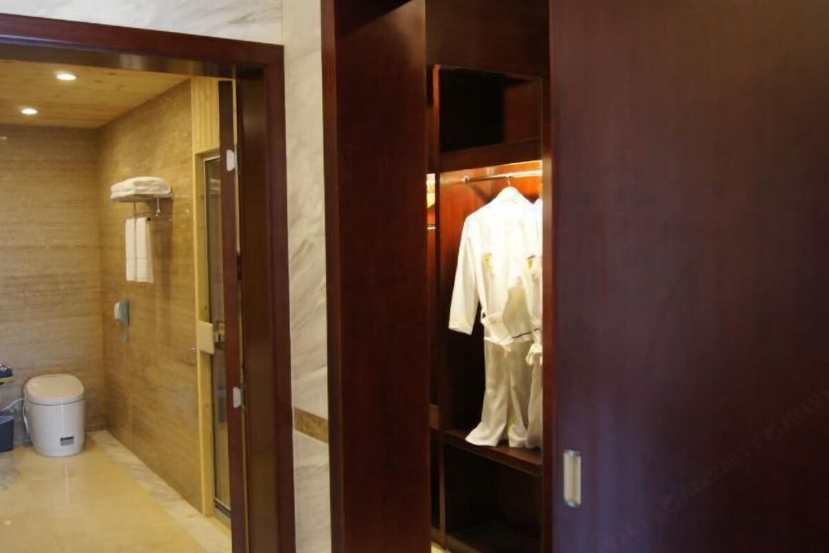 Une salle de bain d’hôtel équipée d’une douche, de toilettes et d’un porte-peignoir.