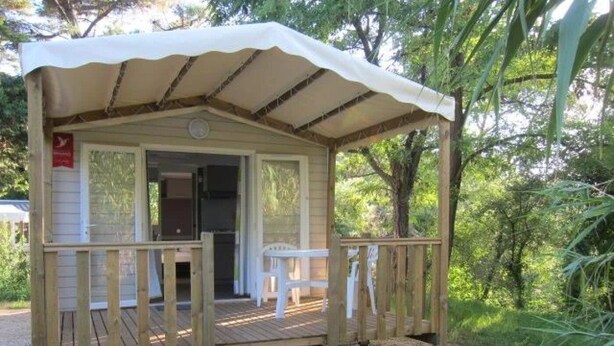 Une petite cabane en bois avec un porche et une entrée abritée.