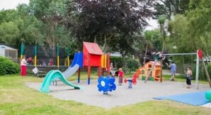 A playground with various play structures including slides and climbing areas.