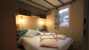 A bedroom with a bed, bedside tables, and a window.