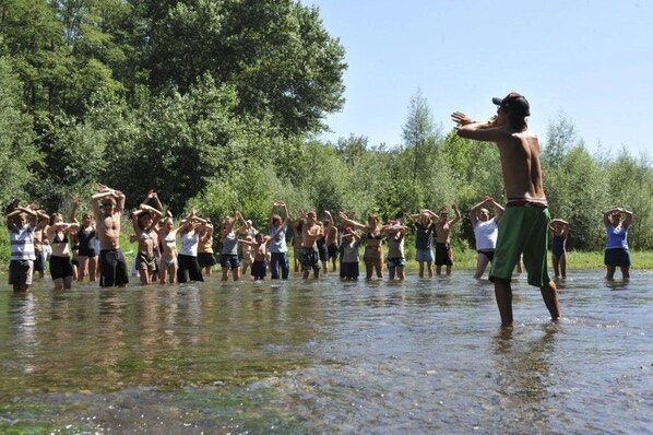 A group of people standing in shallow water, possibly participating in an outdoor activity or exercise.