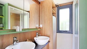 Een moderne badkamer met twee wasbakken, een spiegel en een raam.