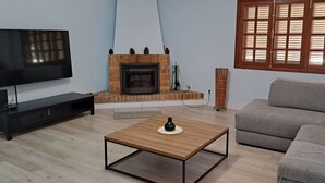 A living room with a TV, a fireplace, a sofa, and a coffee table.