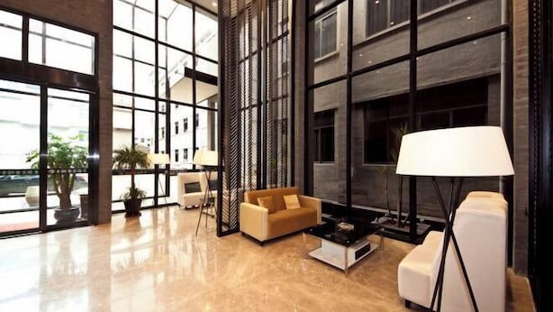 A spacious lobby with a modern design, featuring a large seating area with a sofa and armchairs, a coffee table, and a floor lamp. - Gurun Eco Hotel (Luoyuan)