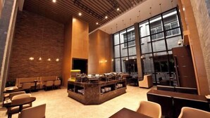 A modern hotel lobby with a central buffet area, seating arrangements, and large windows providing natural light. - Gurun Eco Hotel (Luoyuan)