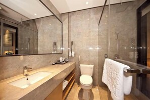 A modern bathroom with a large mirror, a sink, a toilet, and a glass shower enclosure. - Gurun Eco Hotel (Luoyuan)