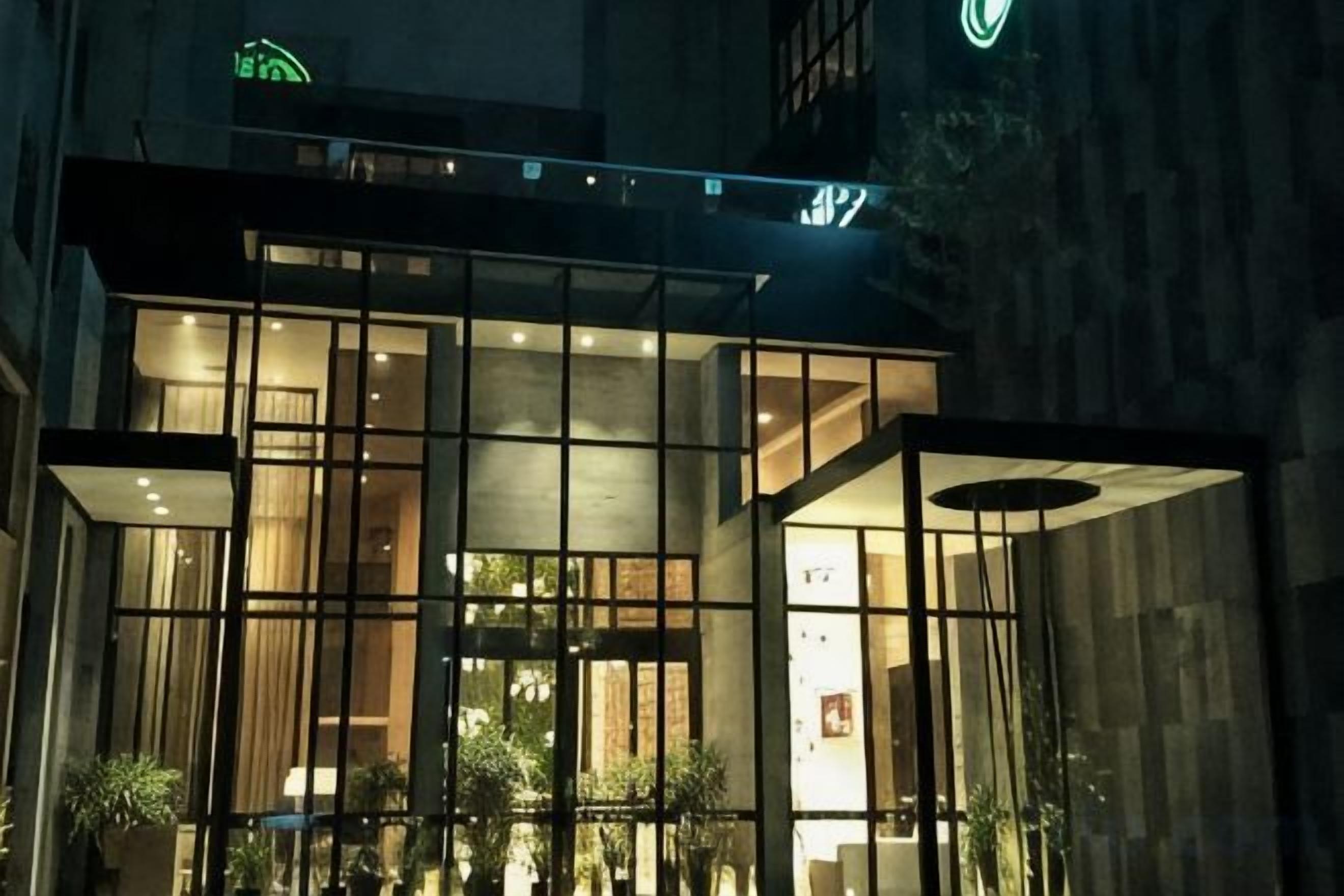 A modern building with large windows and a glass facade, likely a hotel or office.
