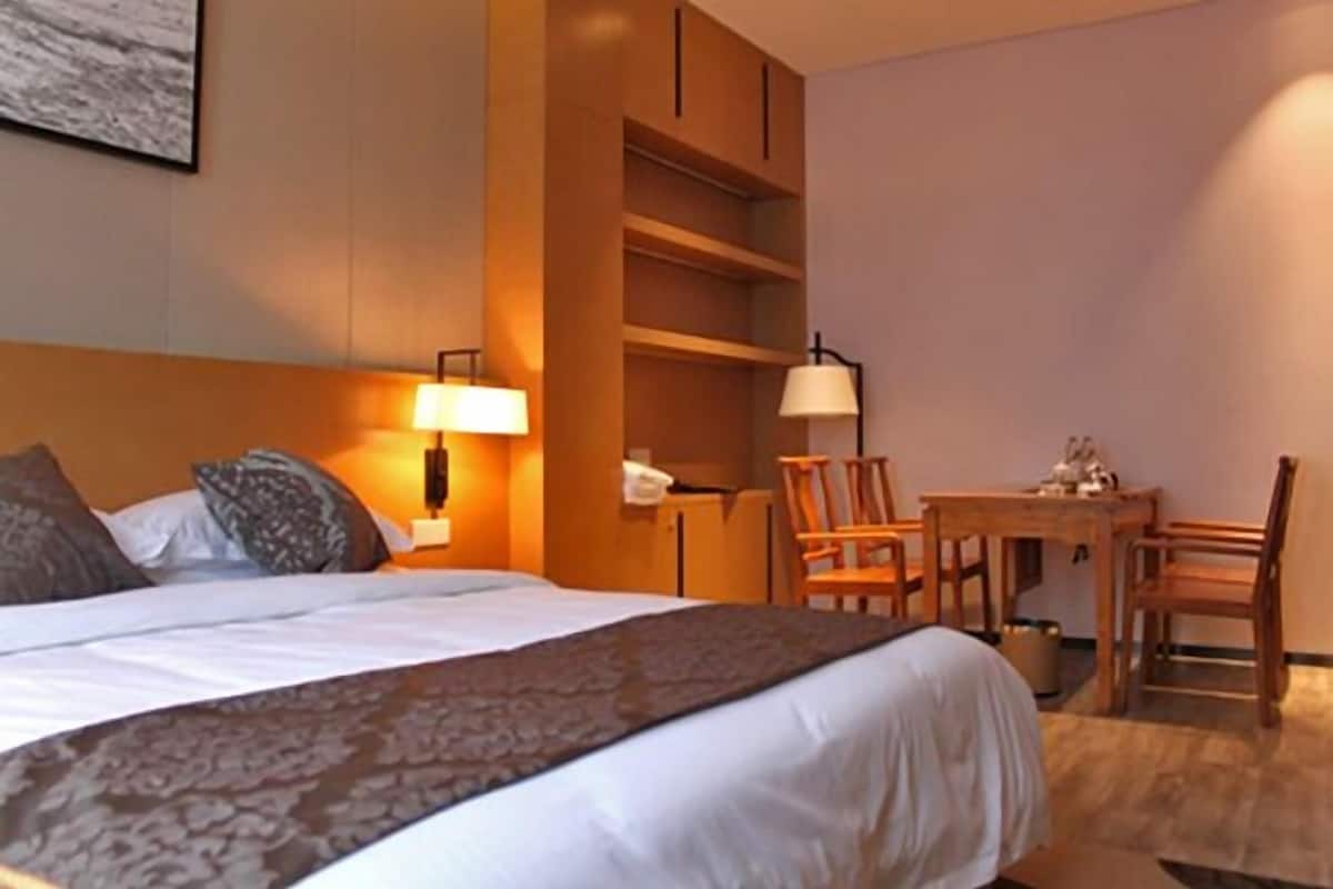 Una habitación de hotel con una cama, un escritorio y una silla.