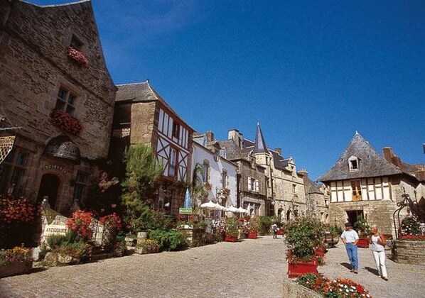 A cobblestone street lined with historic buildings, some with visible signage.