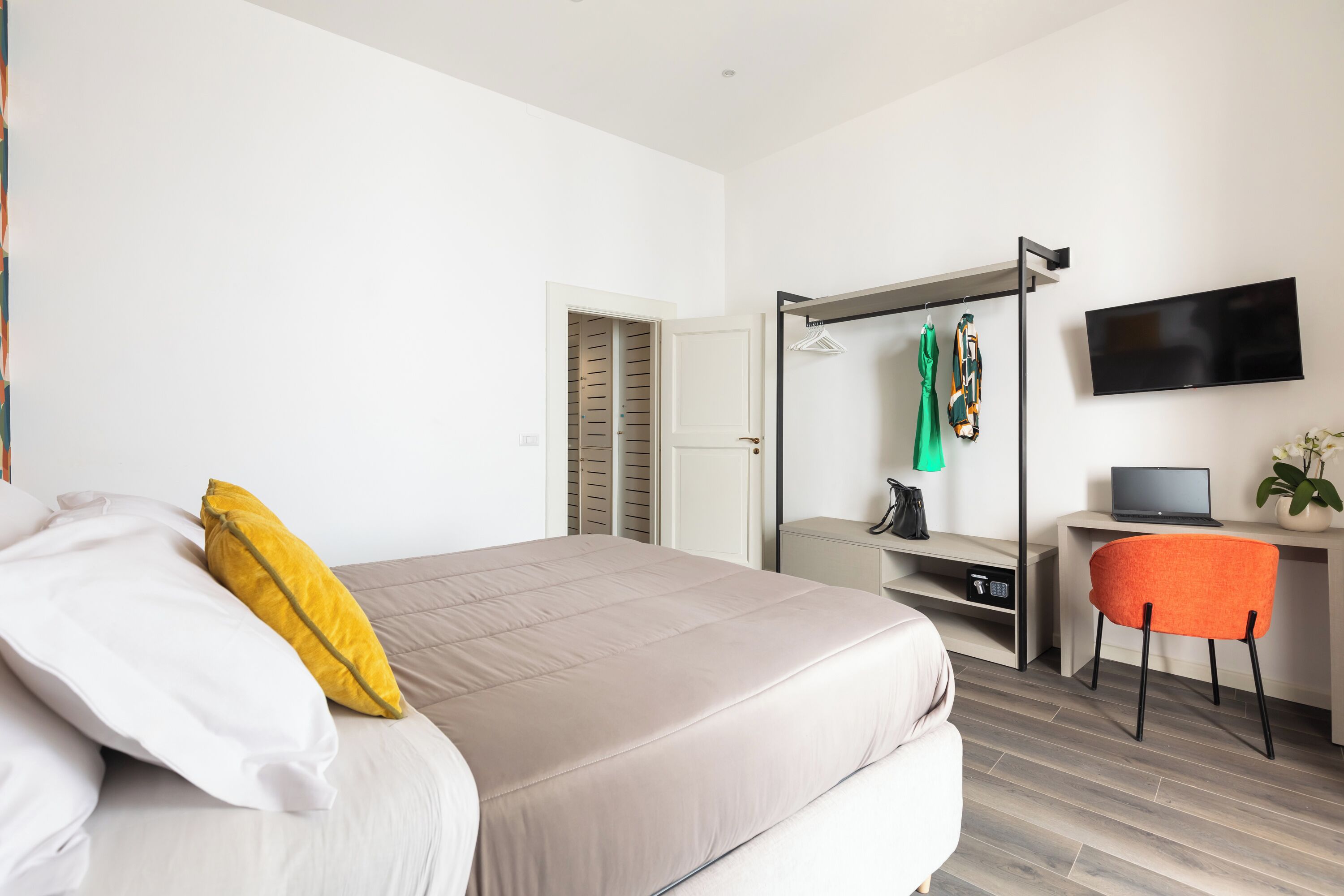 Une chambre à coucher moderne, équipée d’un lit, d’un bureau, d’une chaise et d’un téléviseur.