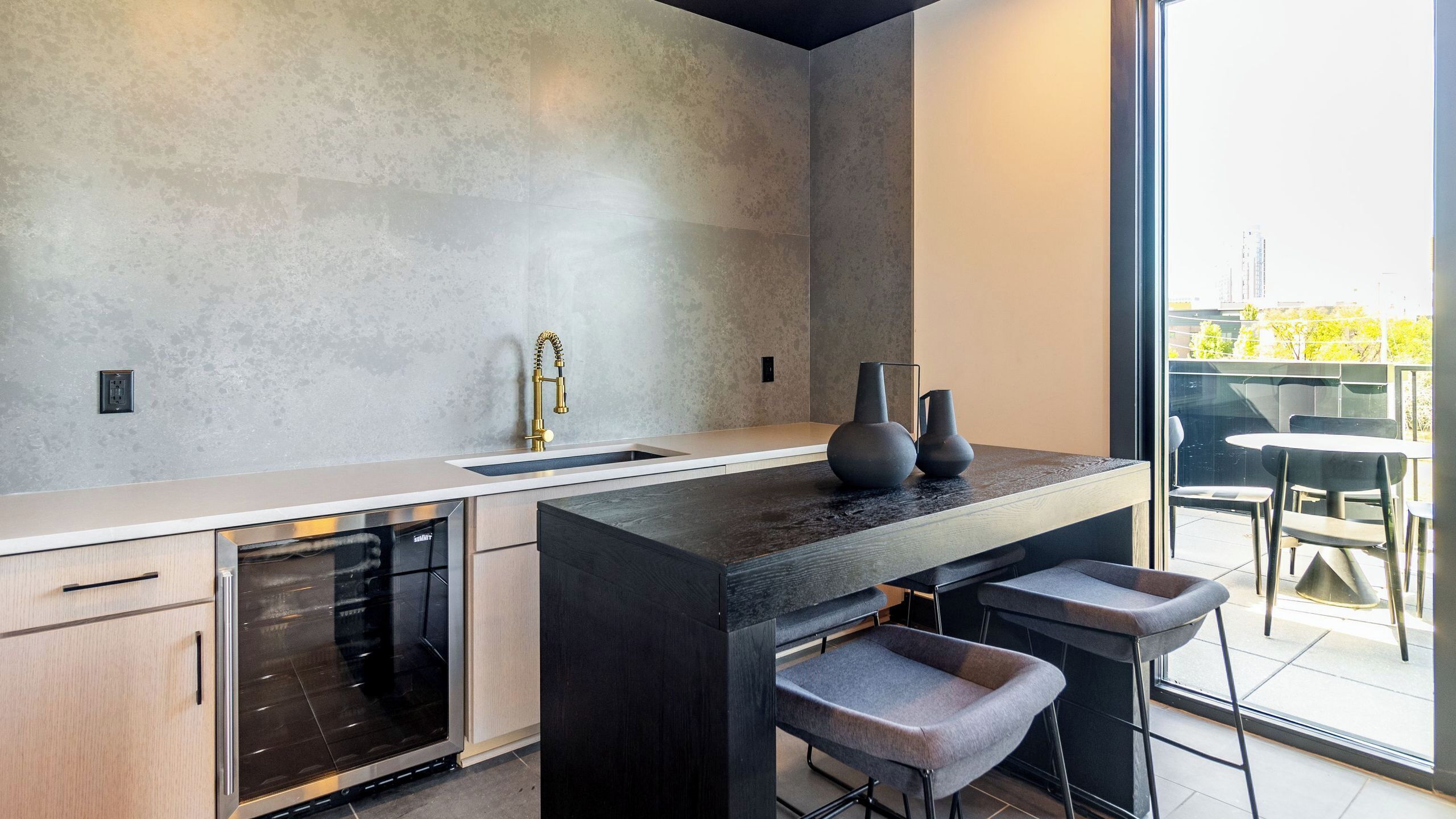 Cocina moderna con una isla grande, electrodomésticos de acero inoxidable y vistas al exterior.