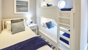 A bedroom with a bunk bed, a bedside table with a lamp, and a painting on the wall. - Host Stay Puffin s Rest (Saltburn-by-the-Sea)