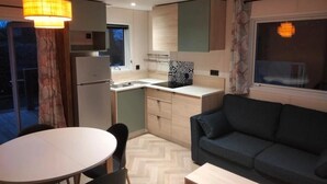 A compact living space with a dining area, kitchenette, and a sofa.