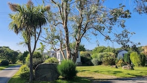 A residential area with a paved driveway, a stone wall, and a house with a well-maintained lawn.