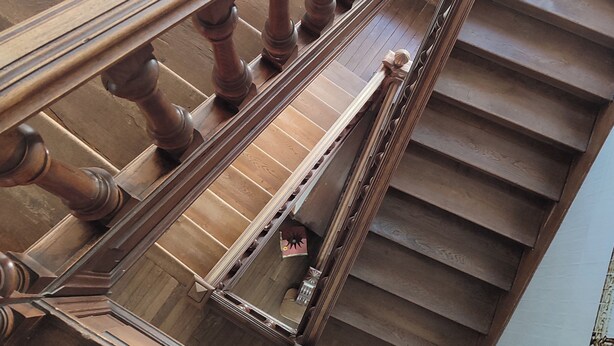 A wooden staircase with ornate balusters and a handrail. - Suite de Charme en Mezzanine (Remiremont)