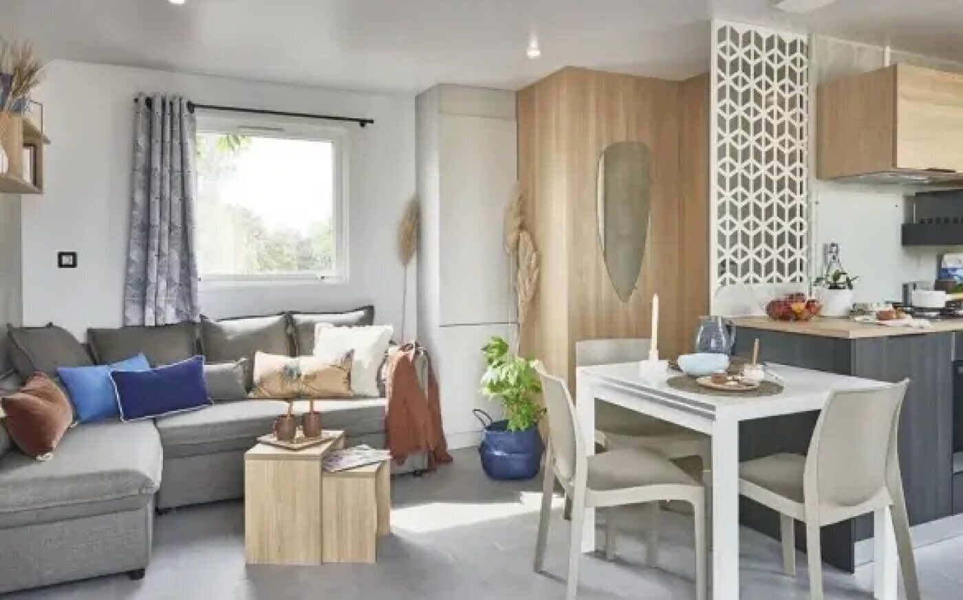 A modern living room with a sofa, coffee table, and dining area with chairs.