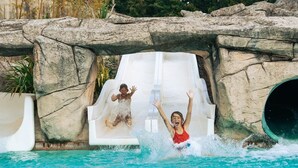 A water slide with a rocky backdrop and a pool at the bottom. - ZEcamping 5* animé parc aquatique tente TV LV BBQ 60m2 (Quimper)