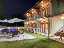 A two-story house with a pool, outdoor seating, and a staircase.
