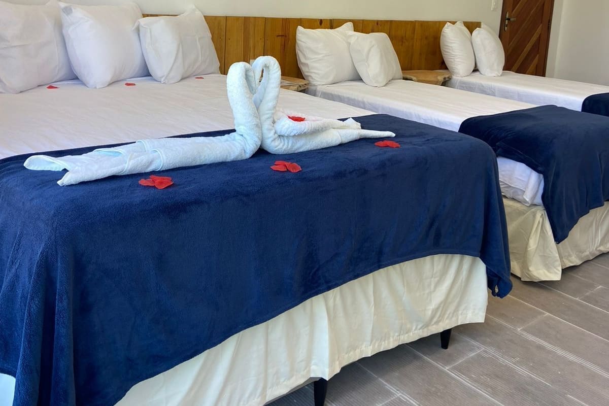 Ein Hotelzimmer mit zwei Betten, jeweils mit blauer und weißer Bettdecke, und einem dekorativen Wandbild darüber.