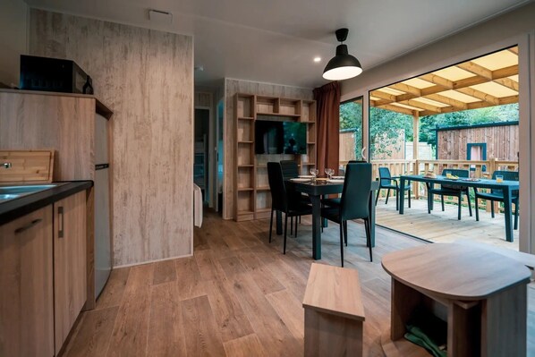 A modern kitchen with wooden cabinetry and a dining area with a table and chairs.