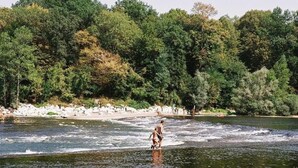 Een rivier met iemand die aan het wakeboarden is.
