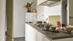 Eine moderne Küche mit Gasherd, Spüle und verschiedenen Kochutensilien.