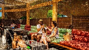 An outdoor seating area with tables and cushioned benches, surrounded by a wooden pergola. - ZEcamping 4* animé 3km plage piscine chauffée tente TV BBQ clim 16m2 (Canet-en-Roussillon)