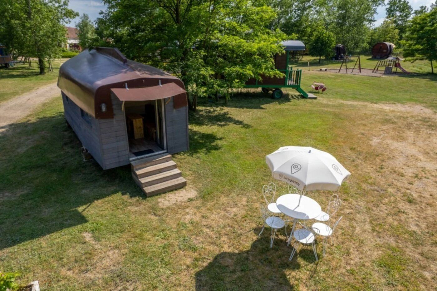 Un petit camping-car d’un seul niveau, doté d’un porche couvert et d’une marche menant à l’entrée.