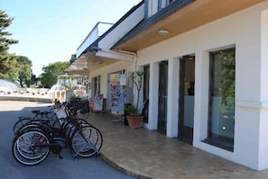 Un edificio con un portico, biciclette parcheggiate all'esterno e una pianta in vaso sul marciapiede.