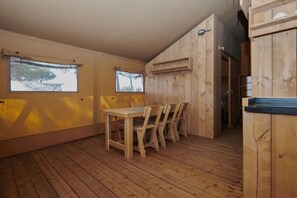 Un intérieur en bois avec une table et des chaises, de grandes fenêtres et un plafond en bois.