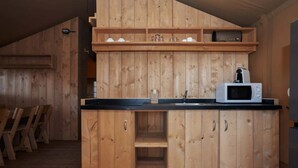 Una cocina de madera con microondas, armarios y un fregadero.
