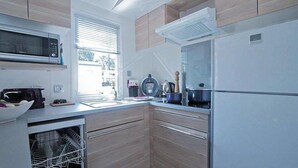 A modern kitchen with a microwave, stove, and refrigerator.