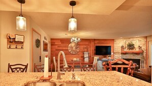 A kitchen with granite countertops, a wooden dining area, and a fireplace.