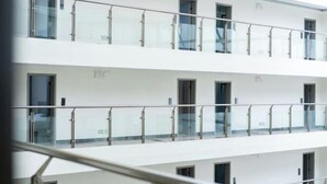 Un hôtel à plusieurs étages, doté de balustrades en verre et d’une façade blanche et épurée.