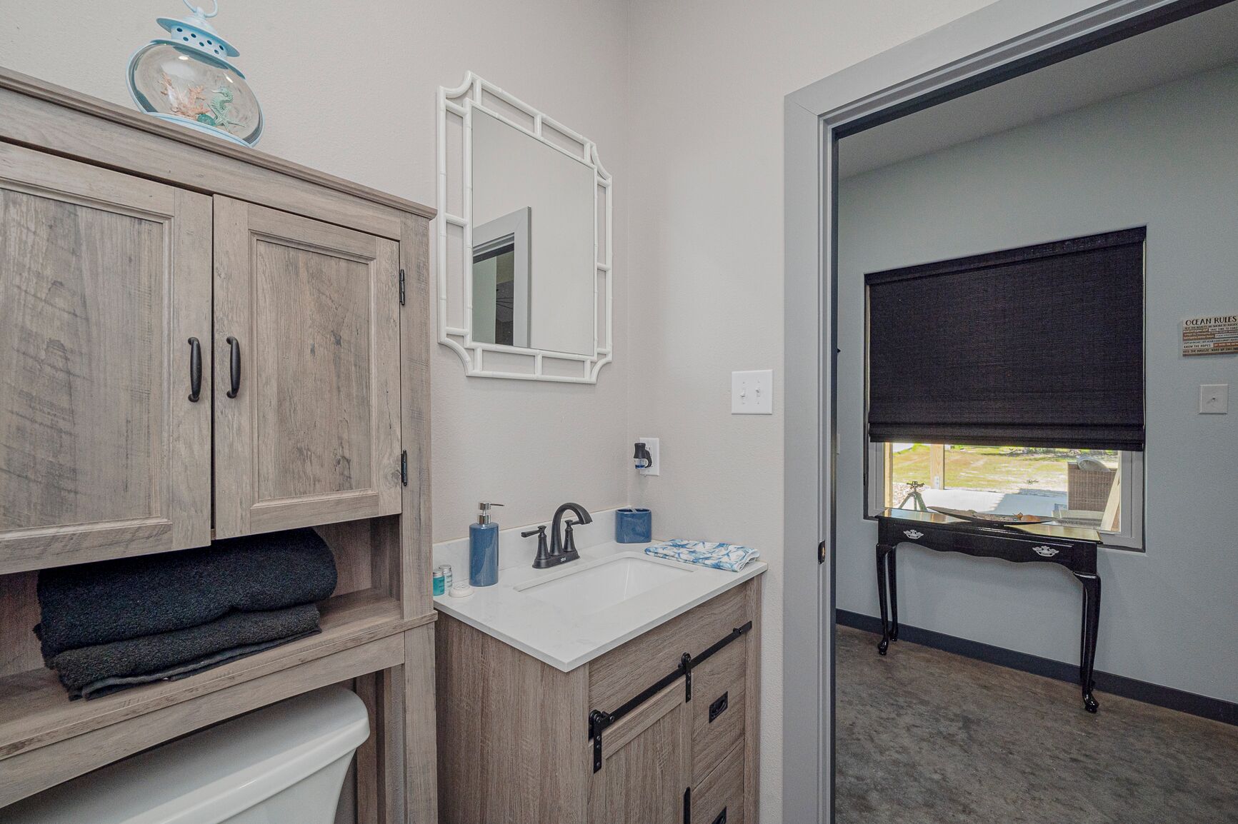 A bathroom with wooden cabinets, a white sink, and a mirror.