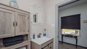 A bathroom with wooden cabinets, a white sink, and a mirror.