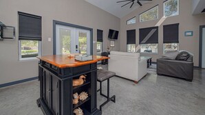 A spacious living area with a modern kitchen, a dining table, and a sofa.