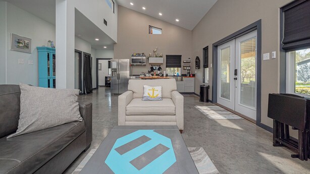 A spacious living area with a sofa, a coffee table, and a kitchen in the background.
