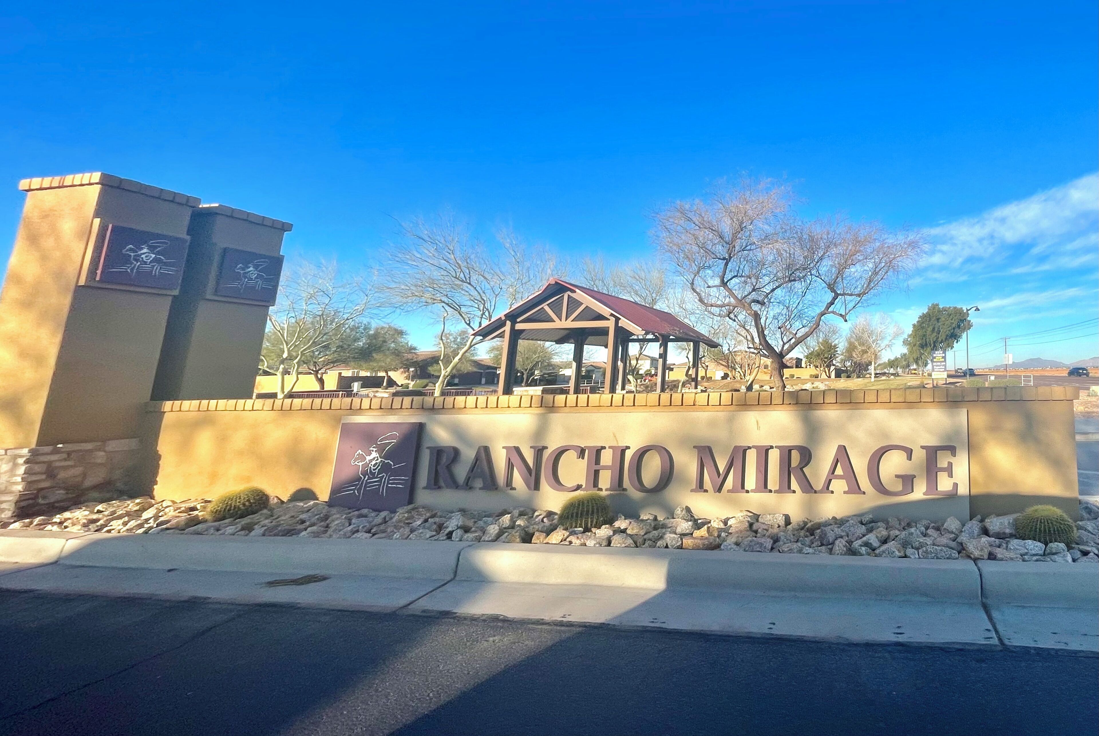A building entrance with a sign reading 'RANCHO MIRAGE' and a covered pavilion structure.