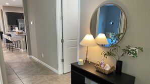 A hallway with a black console table, a mirror, and a potted plant. - Spacious, Family-Friendly Home in Maricopa (Maricopa)