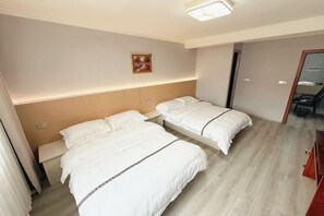 Una habitación de hotel con dos camas, un cabecero, un cuadro y un espejo.